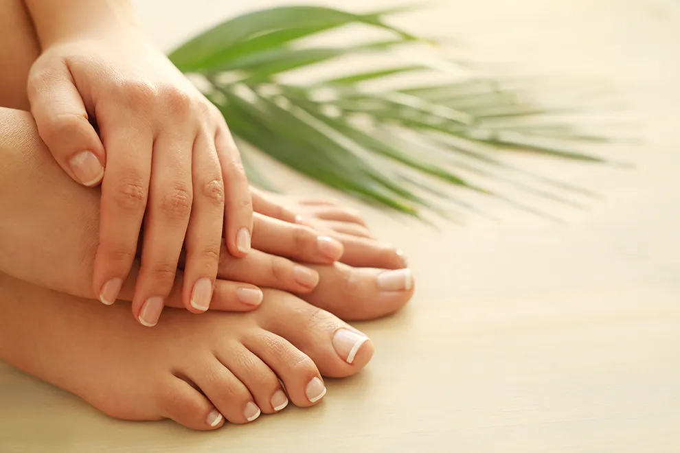 Hands and feet with natural nails on a cream background